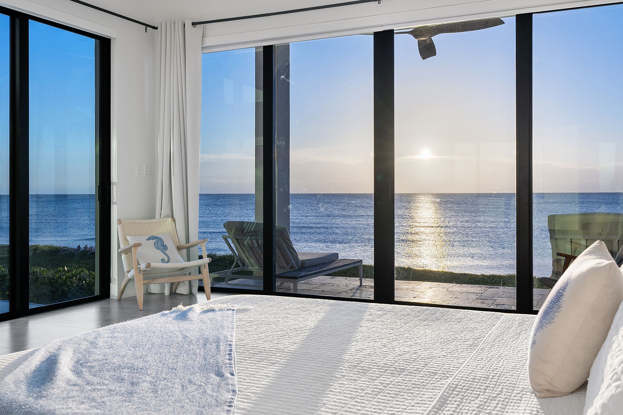 Oceanfront bedroom with floor to ceiling glass